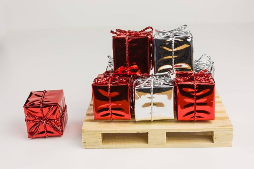 Stacked red and silver wrapped gifts on pallet.