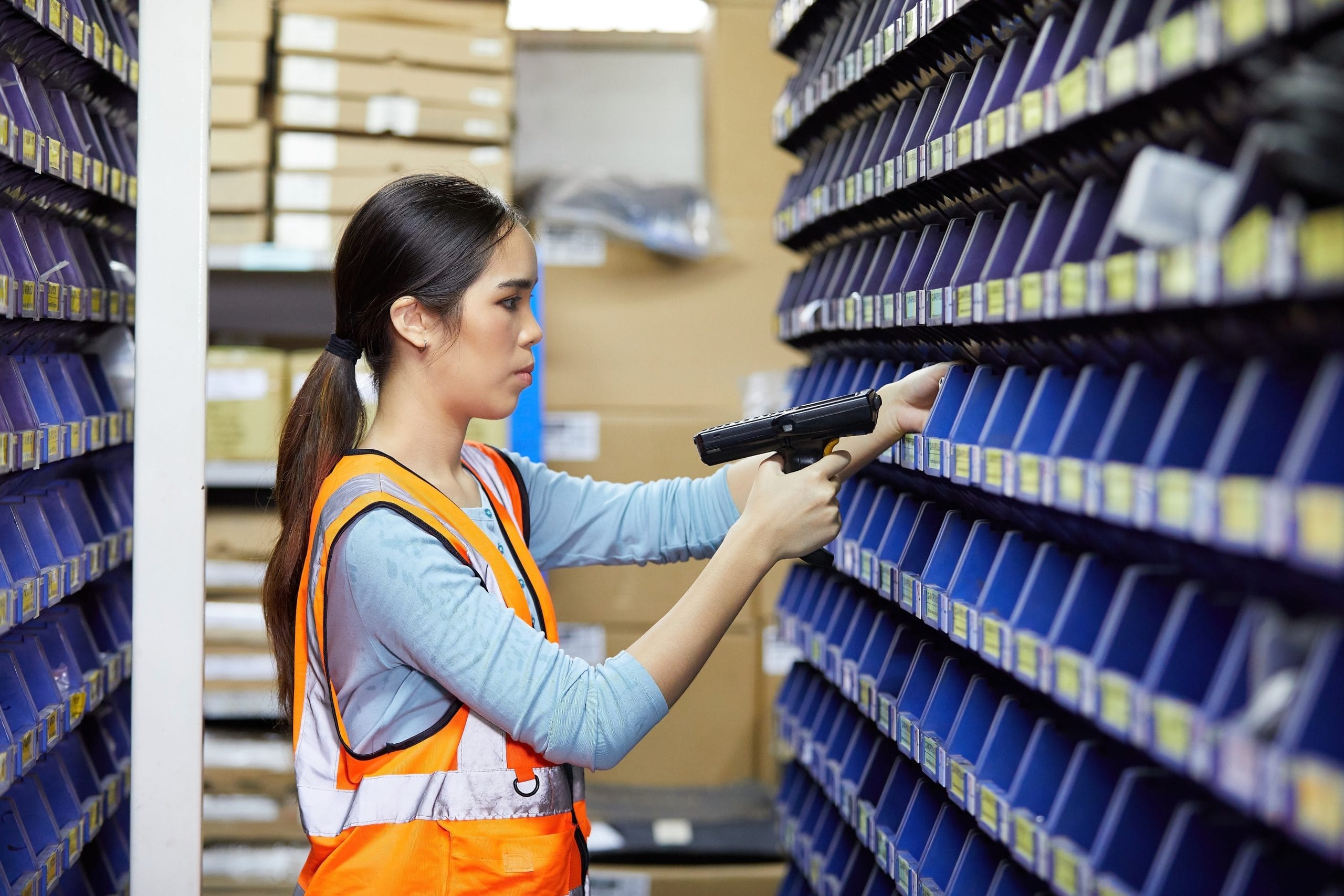 Warehouse worker scanning inventory shelves
