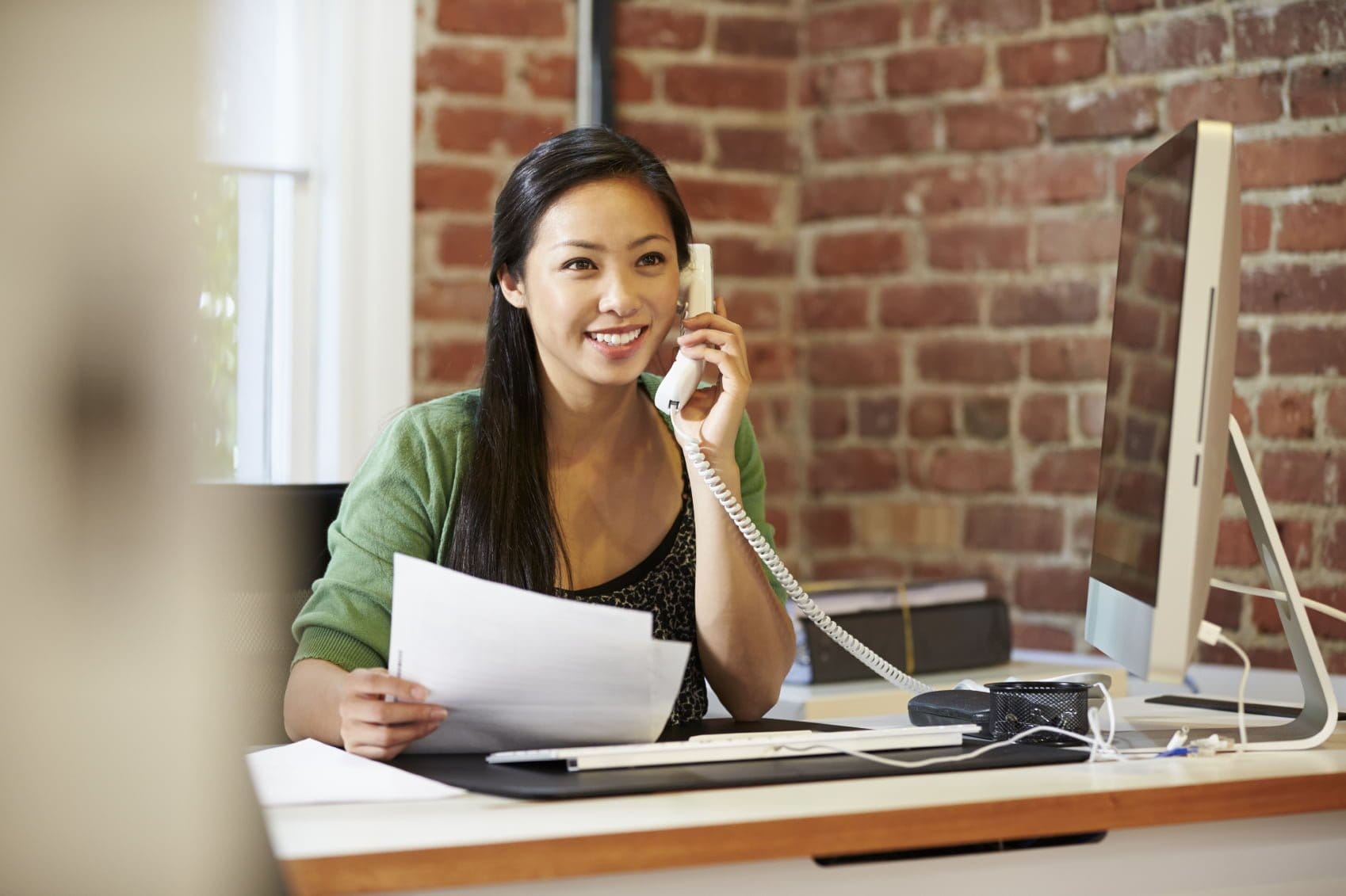 Woman talking on phone in office
